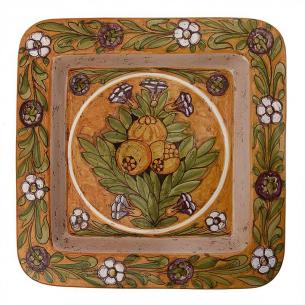 Декоративна тарілка з малюнком гранатів та квітковим візерунком.